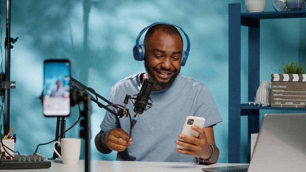 Podcaster being recorded and looking at phone