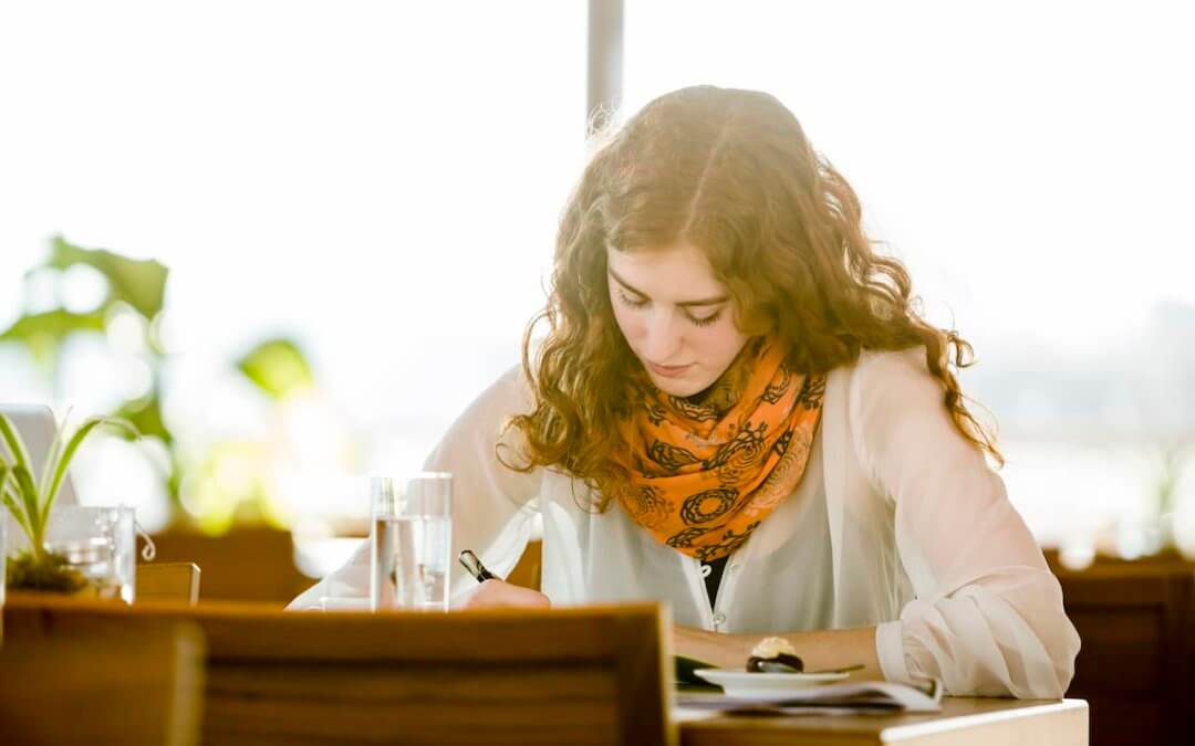 Author writing a prologue while sitting at a desk.