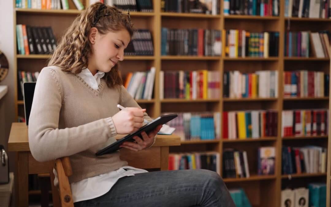 Author brainstorming in front of a bookshelf.